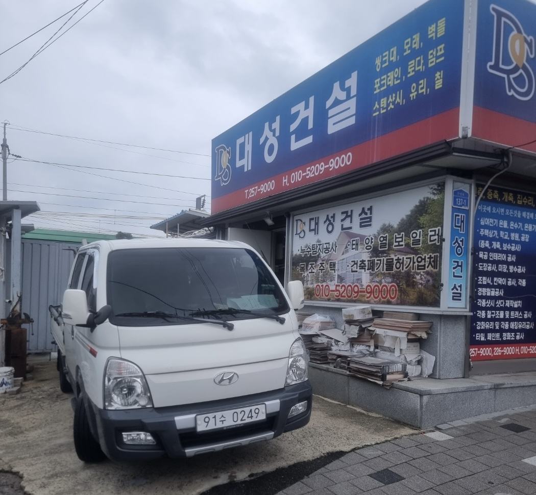 대성건설 사무실 앞 — DS 간판과 작업차량